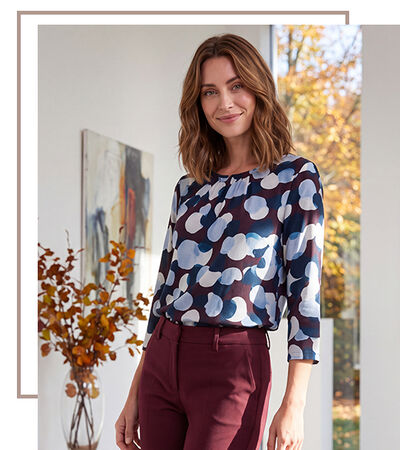 Donkerharige vrouw met een shirt met blauw-donkerrood patroon
